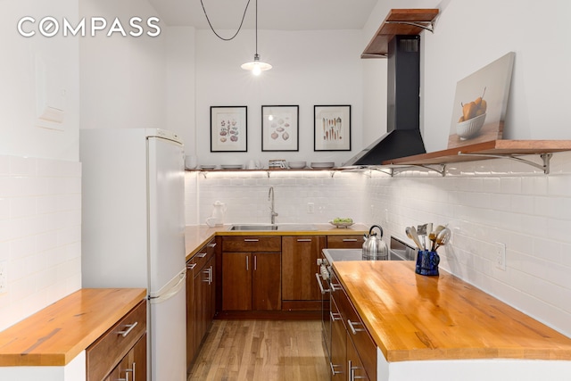140 W 69th St Unit 56A, New York City, NY 10023 - kitchen with butcher block countertops, freestanding refrigerator, decorative backsplash, and light wood-type flooring