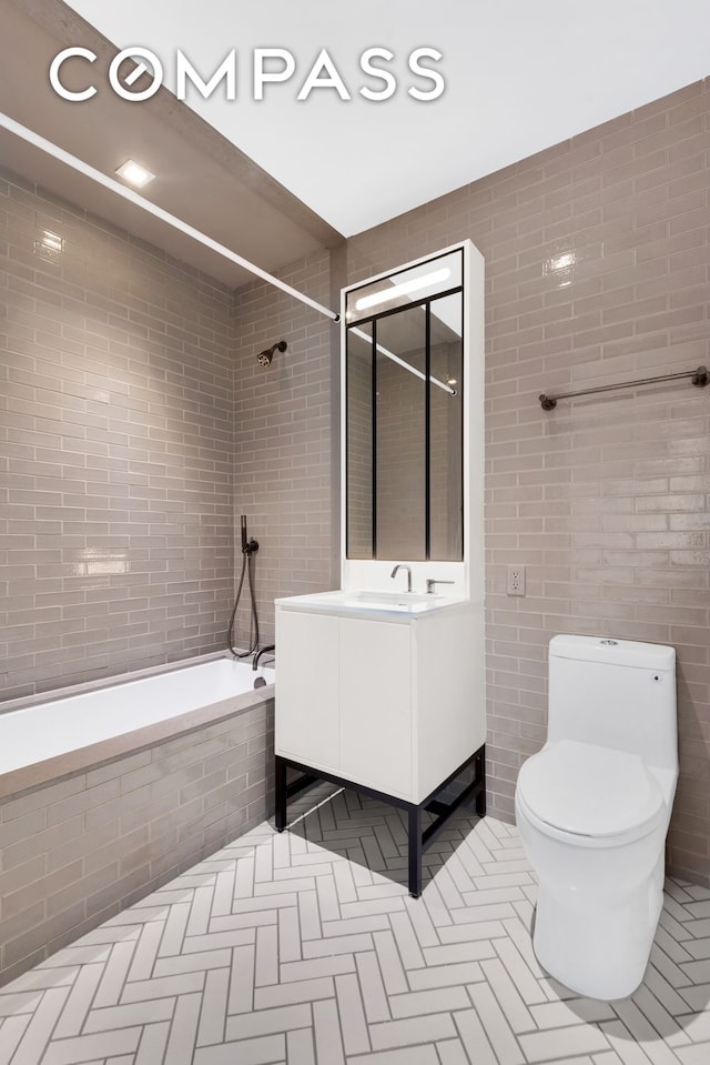 959 1st Ave Unit 6P, New York City, NY 10022 - full bathroom featuring tile walls, tiled shower / bath, vanity, toilet, and tile patterned floors