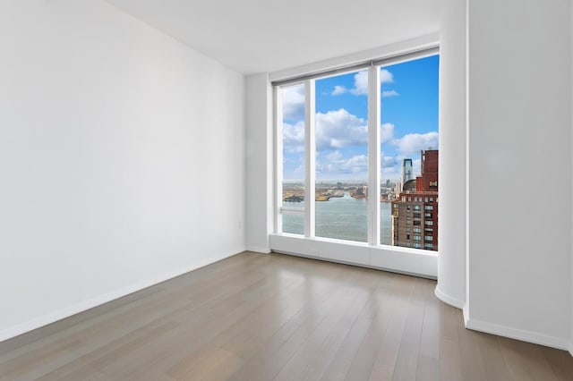50 W St Unit 49-D, New York City, NY 10006 - empty room featuring wood finished floors, a water view, and baseboards