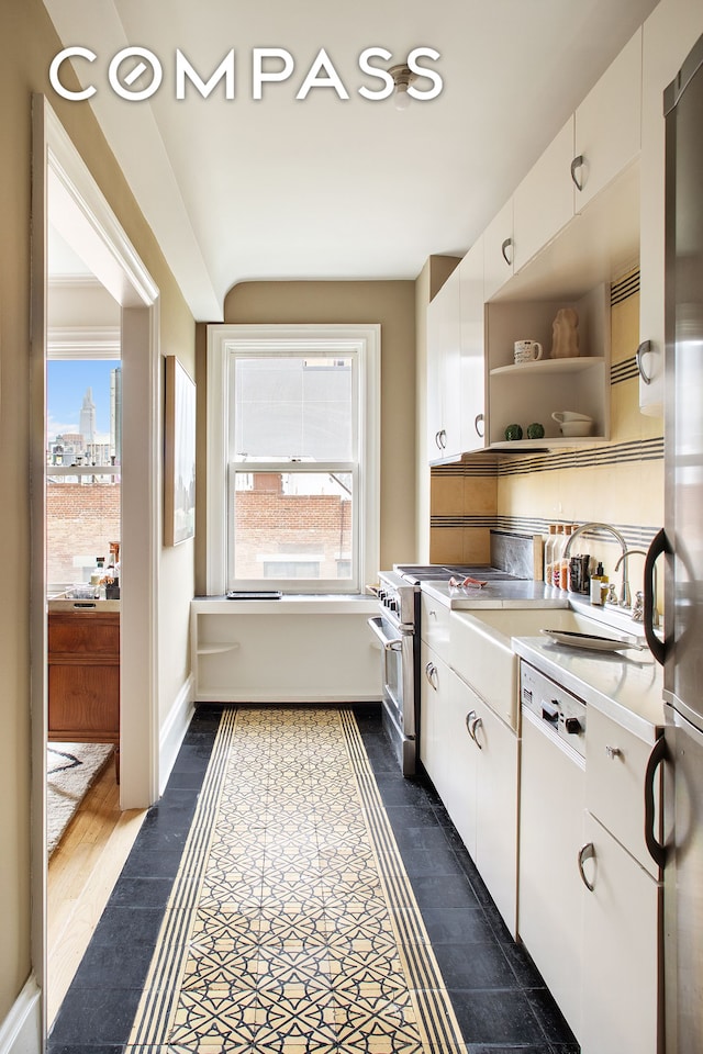 170 2nd Ave Unit 6B, New York City, NY 10003 - kitchen featuring light countertops, open shelves, white cabinets, and high end stainless steel range