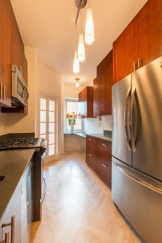 205 E 63rd St Unit 12C, New York City, NY 10065 - kitchen with stainless steel appliances, pendant lighting, dark countertops, and modern cabinets