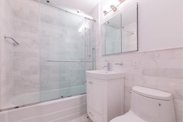 205 E 63rd St Unit 12C, New York City, NY 10065 - full bathroom featuring combined bath / shower with glass door, vanity, and tile walls