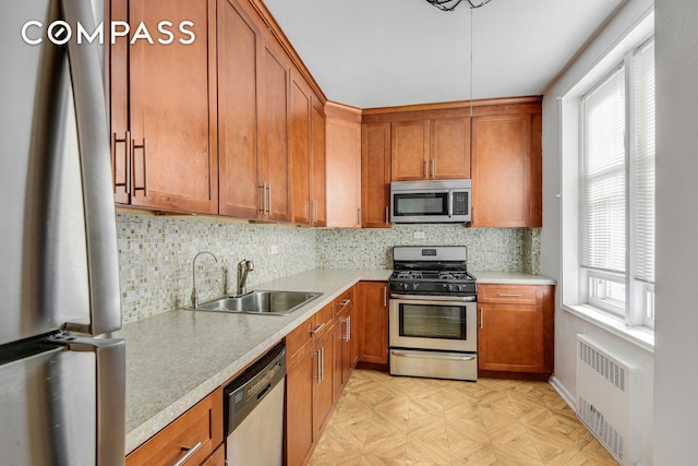 9801 Shore Rd Unit 4P, New York City, NY 11209 - kitchen with stainless steel appliances, radiator heating unit, light countertops, and brown cabinetry