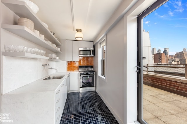 330 3rd Ave Unit 18B, New York City, NY 10010 - kitchen with appliances with stainless steel finishes, open shelves, white cabinets, light countertops, and healthy amount of natural light