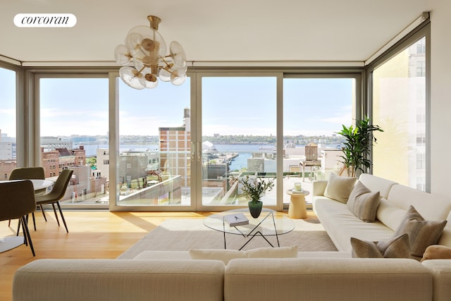 547 W 47th St Unit Ph8, New York City, NY 10036 - living room featuring a chandelier, wood finished floors, a water view, floor to ceiling windows, and a city view