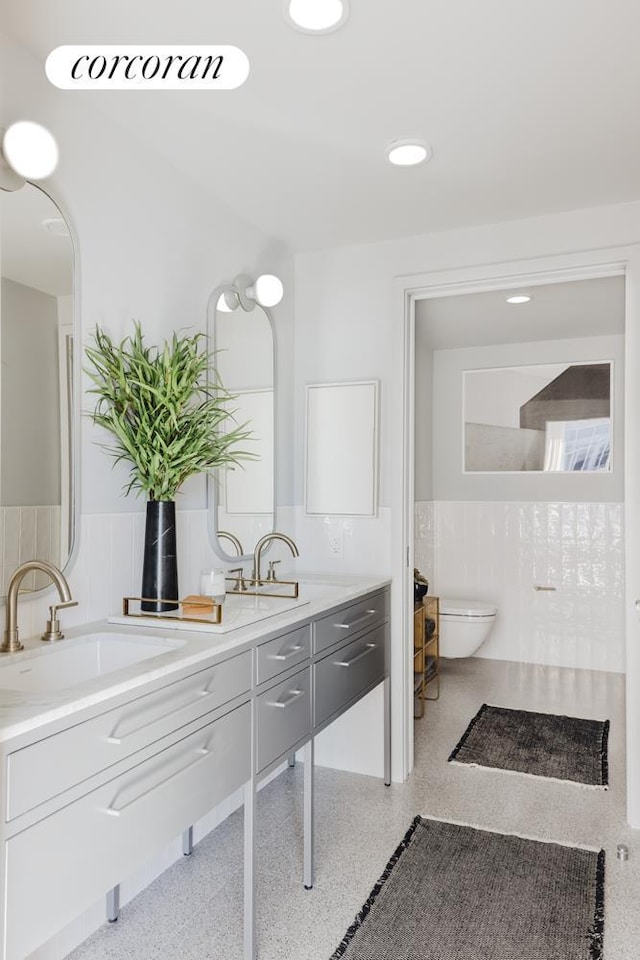 547 W 47th St Unit Ph8, New York City, NY 10036 - bathroom with double vanity, wainscoting, and speckle patterned floor