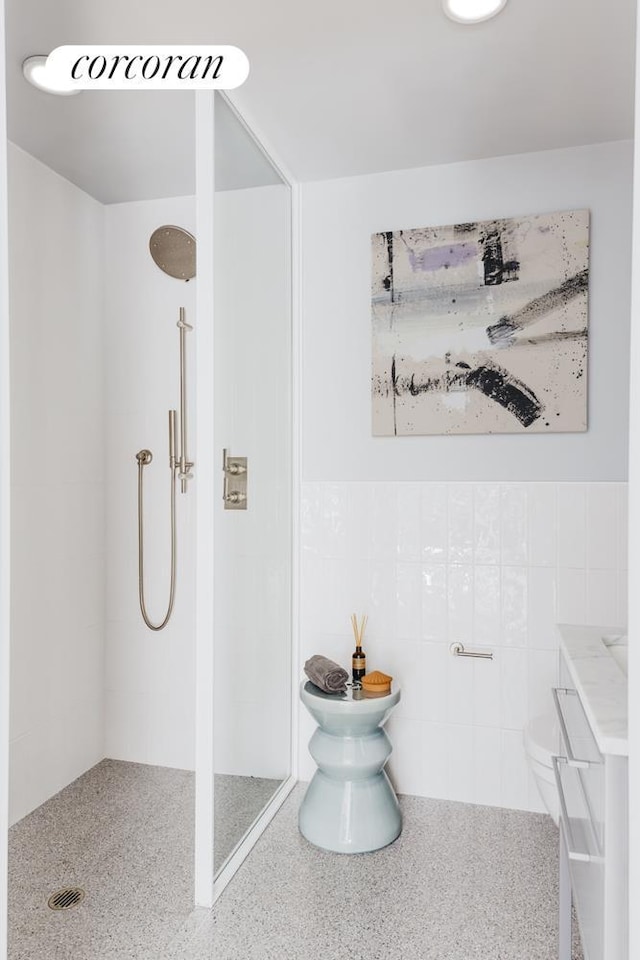547 W 47th St Unit Ph8, New York City, NY 10036 - bathroom with a shower stall, tile walls, and vanity
