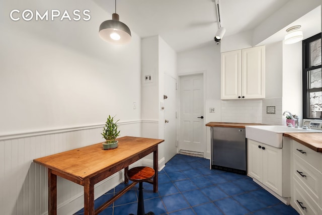 41 Perry St Unit 2A, New York City, NY 10014 - kitchen featuring butcher block countertops, white cabinets, tasteful backsplash, dark tile patterned flooring, and decorative light fixtures