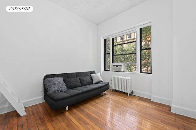 140 W 69th St Unit 26C, New York City, NY 10023 - living area with radiator, wood-type flooring, and cooling unit