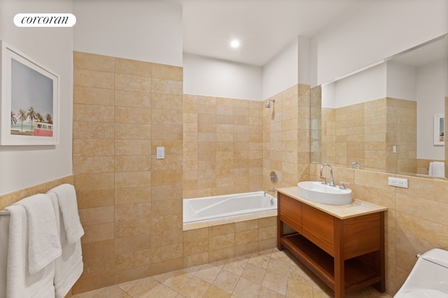 250 E 49th St Unit 3D, New York City, NY 10017 - bathroom with tile walls, a relaxing tiled tub, vanity, and tile patterned flooring