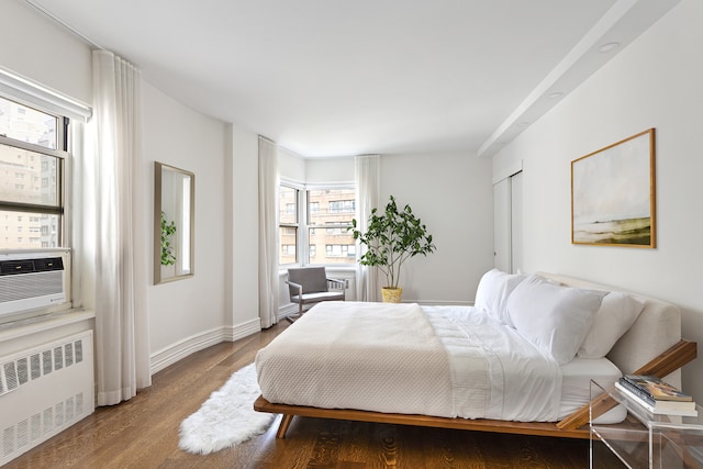 430 E 56th St Unit 11B, New York City, NY 10022 - bedroom featuring radiator heating unit and wood finished floors