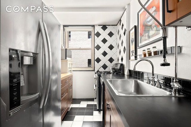 63 E 9th St Unit 4U, New York City, NY 10003 - kitchen featuring stainless steel fridge with ice dispenser, range, brown cabinets, and dark tile patterned floors