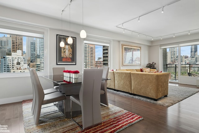 303 E 57th St Unit 14G, New York City, NY 10022 - dining area featuring track lighting, wood finished floors, and a city view