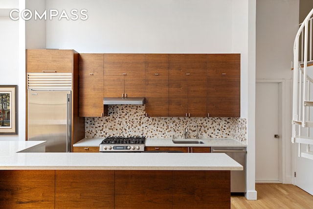 55 Hudson St Phe, Phe, New York City, NY 10013 - kitchen with stainless steel appliances, under cabinet range hood, decorative backsplash, light wood-style flooring, and light countertops