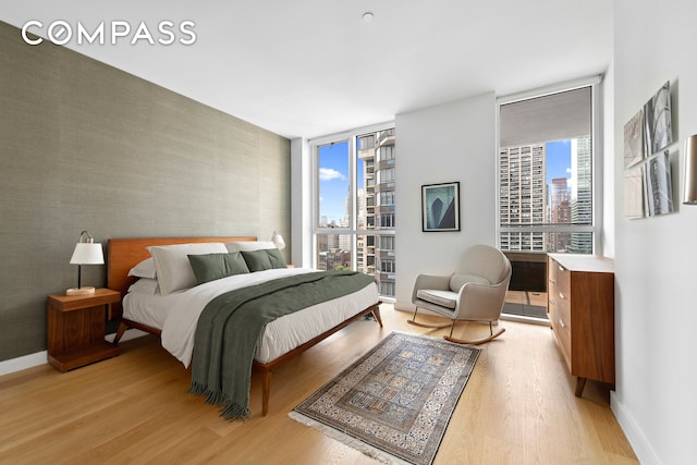 301 E 61st St Unit 12B, New York City, NY 10065 - bedroom with a wall of windows, multiple windows, light wood-type flooring, and a view of city
