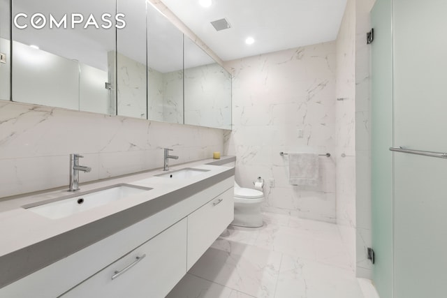 301 E 61st St Unit 12B, New York City, NY 10065 - bathroom featuring tile walls, double vanity, marble finish floors, recessed lighting, and a marble finish shower