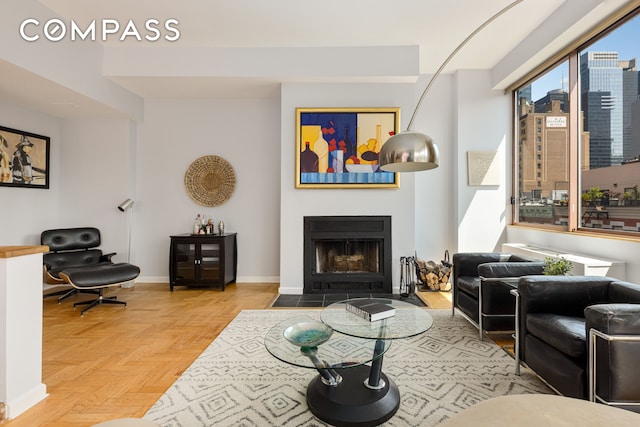 393 W 49th St Unit 5C, New York City, NY 10019 - living area featuring a fireplace with flush hearth and baseboards