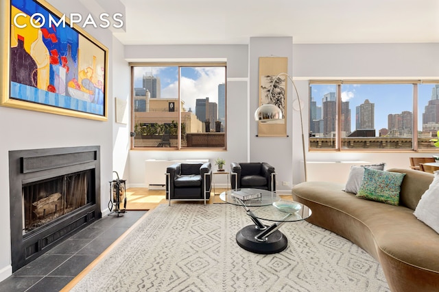 393 W 49th St Unit 5C, New York City, NY 10019 - living room with a view of skyline, a fireplace with flush hearth, and dark tile patterned floors
