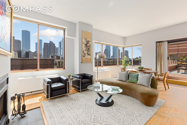 393 W 49th St Unit 5C, New York City, NY 10019 - living room with a view of skyline and a fireplace with flush hearth