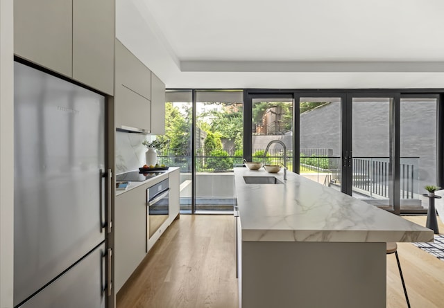 153 Green St Unit 1B, New York City, NY 11222 - kitchen featuring stainless steel appliances, gray cabinets, light wood-style flooring, and modern cabinets