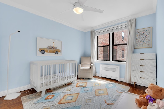 160 W 85th St Unit 5H, New York City, NY 10024 - bedroom featuring crown molding, a crib, wood finished floors, and a ceiling fan