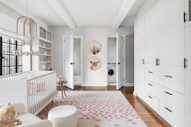 227 E 57th St Unit 12Eg, New York City, NY 10022 - bedroom with stacked washing machine and dryer, beam ceiling, dark wood-type flooring, and a nursery area
