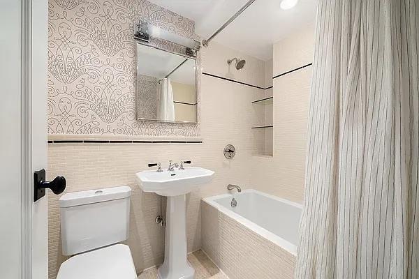 227 E 57th St Unit 12Eg, New York City, NY 10022 - bathroom featuring tiled shower / bath combo and tile walls
