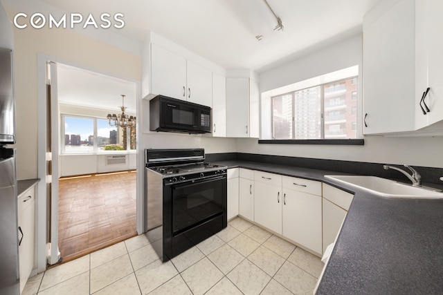 45 Sutton Pl S Unit 14N, New York City, NY 10022 - kitchen with black appliances, dark countertops, a chandelier, and white cabinetry