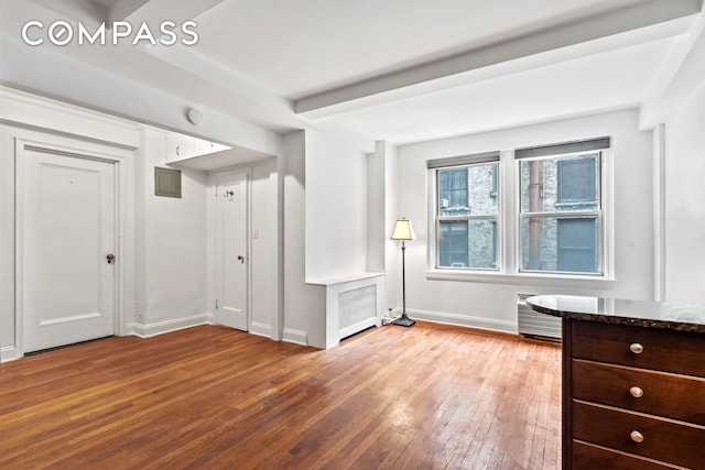 155 E 49th St Unit 8C, New York City, NY 10017 - interior space with light wood finished floors, beamed ceiling, and radiator heating unit
