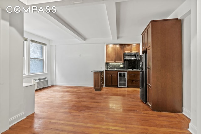 155 E 49th St Unit 8C, New York City, NY 10017 - kitchen with beverage cooler, black appliances, backsplash, beamed ceiling, and light wood-style flooring