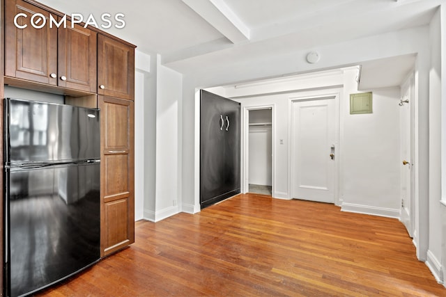 155 E 49th St Unit 8C, New York City, NY 10017 - kitchen with freestanding refrigerator, light wood-type flooring, and beamed ceiling