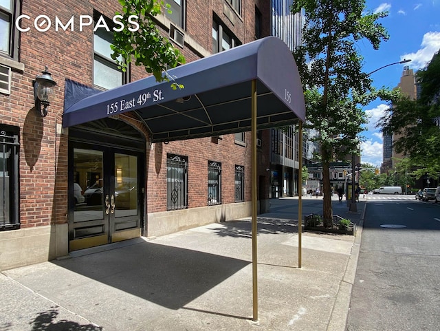 155 E 49th St Unit 8C, New York City, NY 10017 - doorway to property featuring brick siding and french doors
