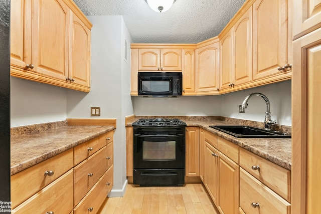 77 Fulton St Unit 9N, New York City, NY 10038 - kitchen featuring black appliances, light brown cabinetry, light wood-type flooring, a textured ceiling, and light countertops