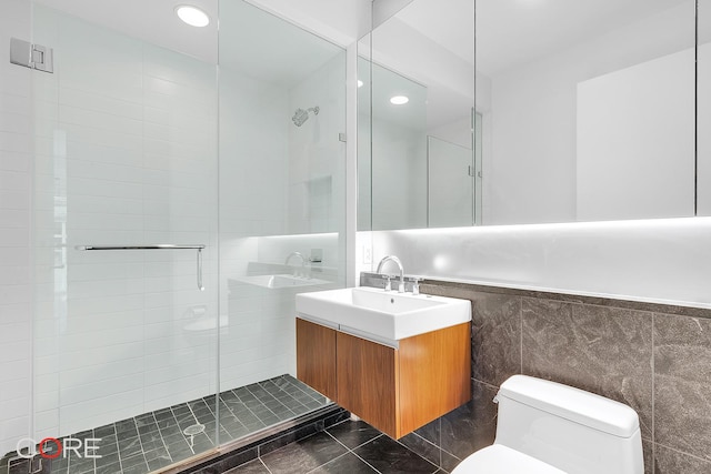 311 W Broadway Unit 3C, New York City, NY 10013 - bathroom with tile walls, vanity, a shower stall, and recessed lighting
