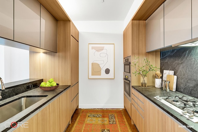311 W Broadway Unit 3C, New York City, NY 10013 - kitchen featuring modern cabinets, dark stone countertops, white gas cooktop, light wood-style floors, and stainless steel double oven