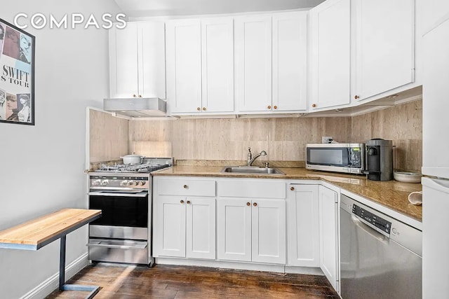 250 W 22nd St Unit 2C, New York City, NY 10011 - kitchen featuring appliances with stainless steel finishes, under cabinet range hood, tasteful backsplash, dark wood finished floors, and white cabinets