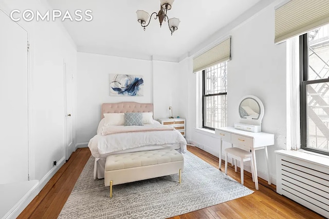 250 W 22nd St Unit 2C, New York City, NY 10011 - bedroom featuring a chandelier and wood-type flooring
