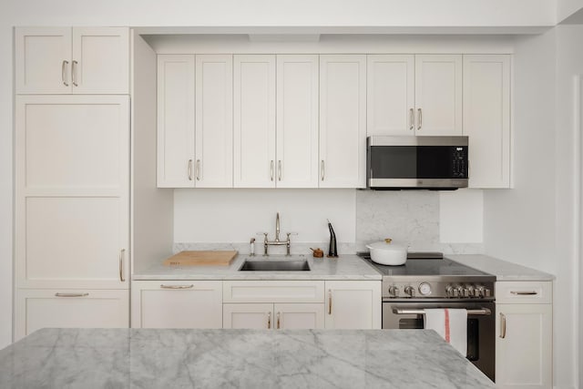 186 Clinton St Unit 4B, New York City, NY 11201 - kitchen with stainless steel appliances, white cabinets, and light stone counters