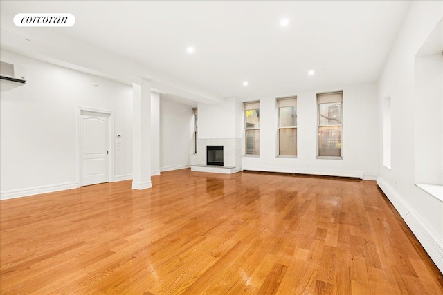 458 W 146th St Unit 2S, New York City, NY 10031 - unfurnished living room featuring a glass covered fireplace, light wood finished floors, recessed lighting, a baseboard radiator, and a wall mounted air conditioner