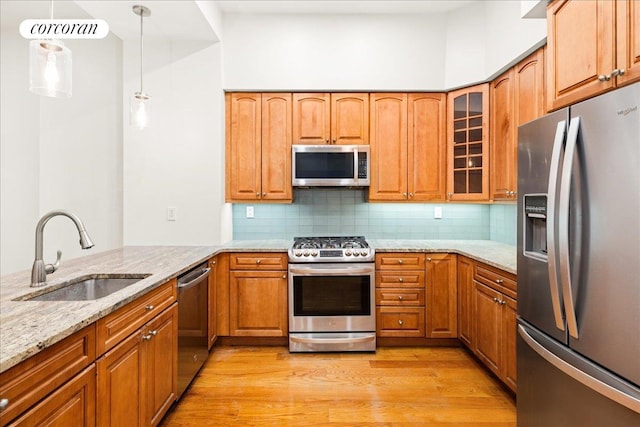 458 W 146th St Unit 2S, New York City, NY 10031 - kitchen featuring appliances with stainless steel finishes, light stone countertops, light wood-style flooring, glass insert cabinets, and tasteful backsplash