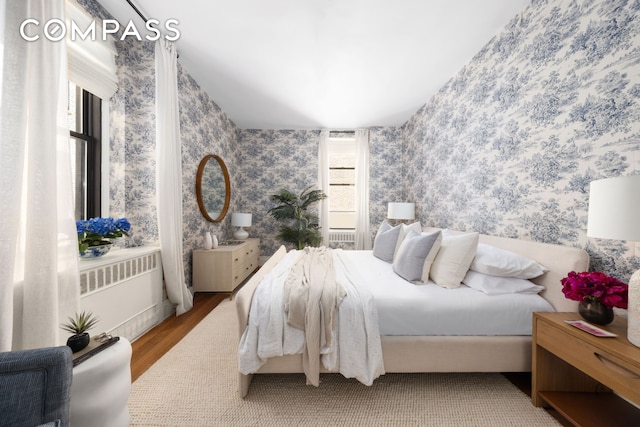 993 Park Ave Unit 4C, New York City, NY 10028 - bedroom with radiator, wallpapered walls, and wood finished floors