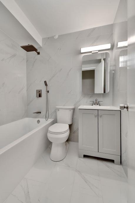 10 Park Ave Unit 4-C, New York City, NY 10016 - full bath featuring bathing tub / shower combination, vanity, tile walls, and marble finish floors
