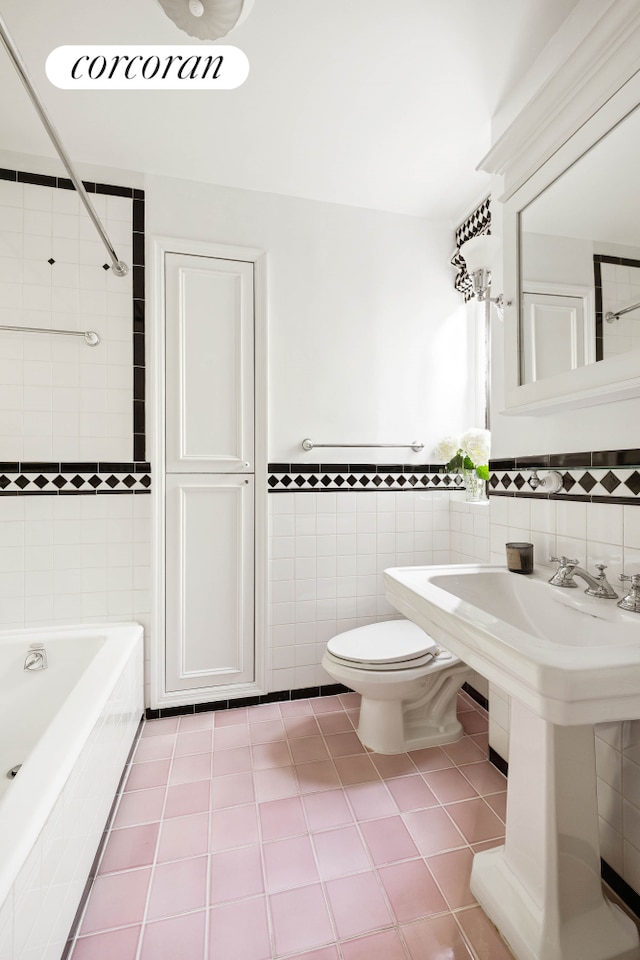 120 W 70th St Unit 1D, New York City, NY 10023 - full bathroom with tile walls, tile patterned flooring, a wainscoted wall, and tiled shower / bath