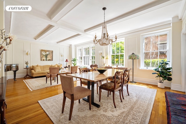 120 W 70th St Unit 1D, New York City, NY 10023 - dining area with a chandelier, a decorative wall, light wood-style flooring, and beamed ceiling
