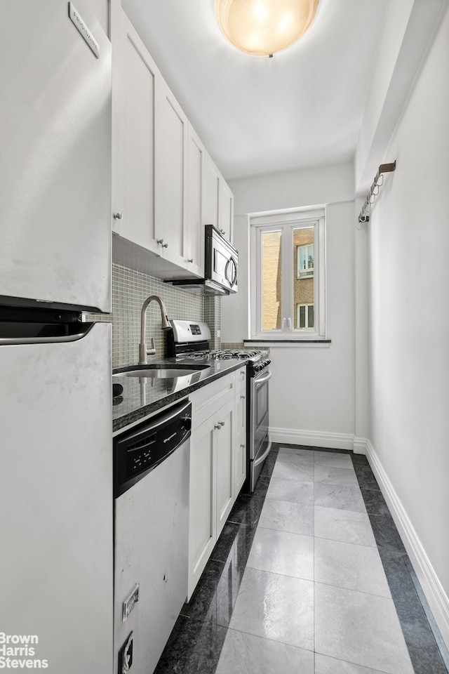 333 W 57th St Unit 704, New York City, NY 10019 - kitchen featuring appliances with stainless steel finishes, white cabinetry, decorative backsplash, and dark countertops