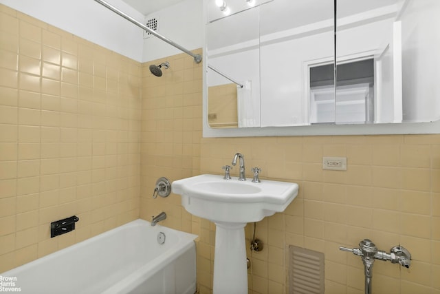 333 W 57th St Unit 704, New York City, NY 10019 - bathroom featuring tub / shower combination, tile walls, and decorative backsplash