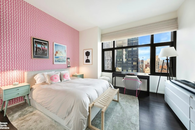 50 United Nations Plz Unit 28B, New York City, NY 10017 - bedroom featuring an accent wall, wood finished floors, wallpapered walls, and a view of city