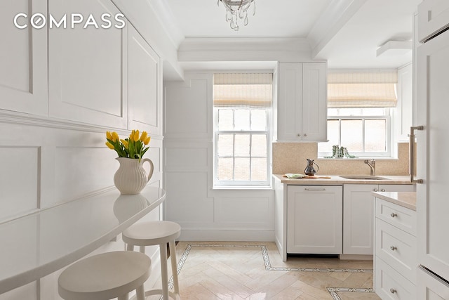 71 E 77th St Unit 8A, New York City, NY 10075 - kitchen with a decorative wall, light countertops, white cabinets, ornamental molding, and backsplash