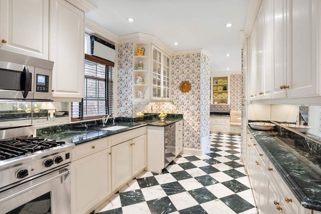 1105 Park Ave Unit 6D, New York City, NY 10128 - kitchen featuring stainless steel appliances, light flooring, backsplash, glass insert cabinets, and dark stone counters