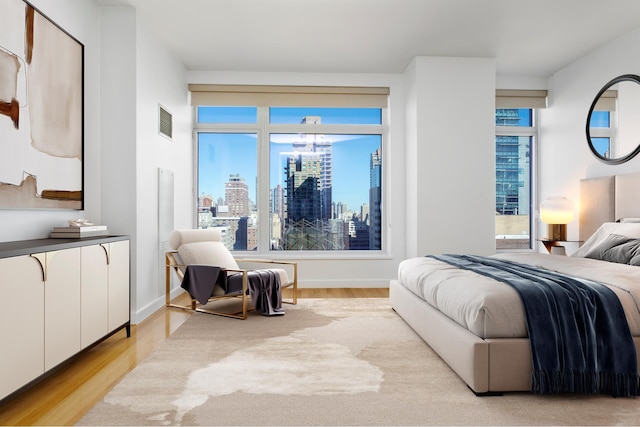 400 E 67th St Unit 20B, New York City, NY 10065 - bedroom with light wood-type flooring and a skyline view